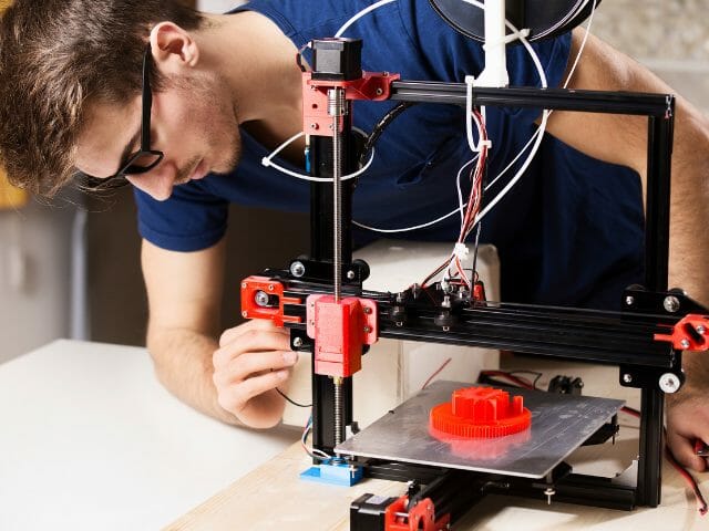student fixing a 3d printer